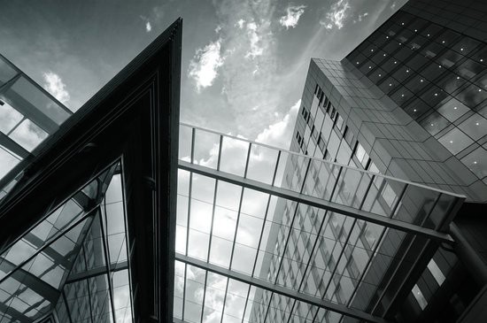A grayscale image of glass buildings.